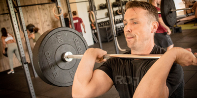 Ten sessions Strong_middle_aged_man_holding_barbell_in_front_rack.jpg
